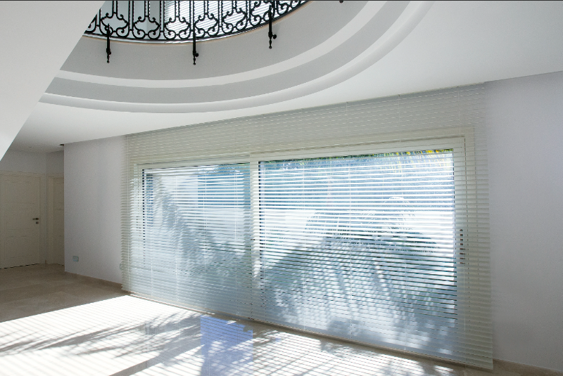 Installation de stores vénitiens Bandalux dans une maison par l’Ouverture Française.