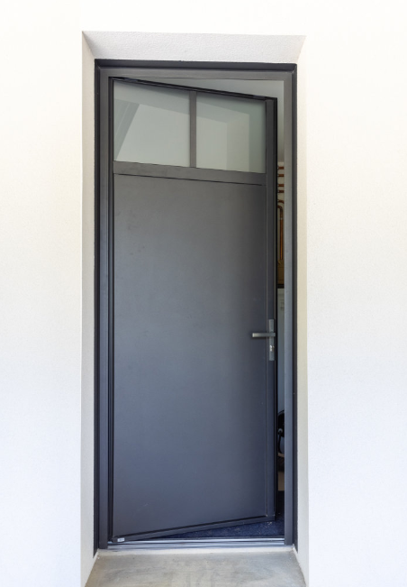 Installation de porte de service pleine en aluminium et acier à un vantail de la marque Millet par L’ouverture Française.