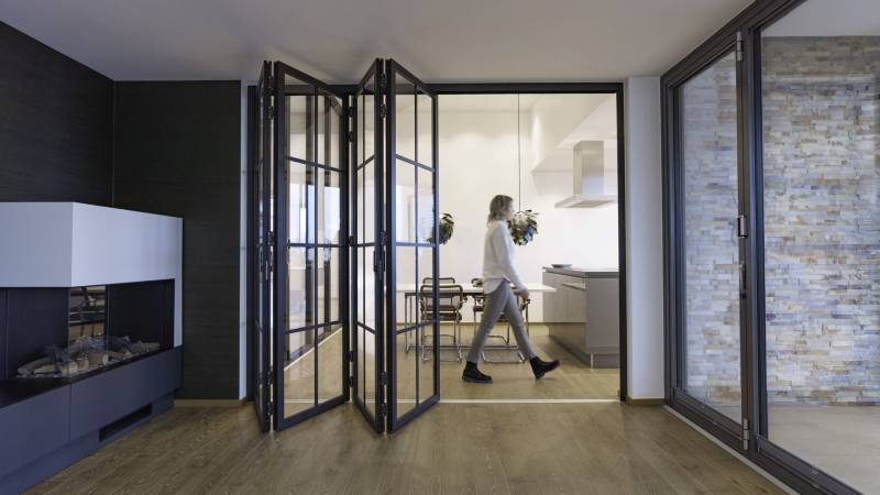 Pose en applique de baie accordéon coulissante en aluminium Solarlux entre les salons à La Valentine près de Gémenos par L’Ouverture Française.